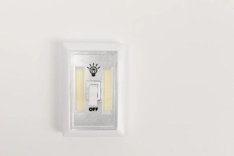 Light switch set to 'OFF' on a white wall.